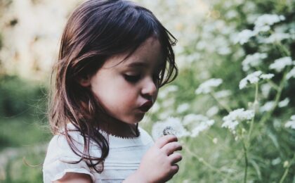 girl holding white flower during daytime