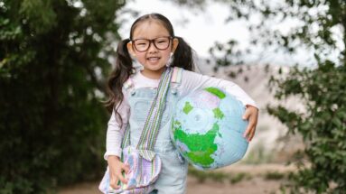 Smiling Girl Holding an Inflatable Globe. self-esteem