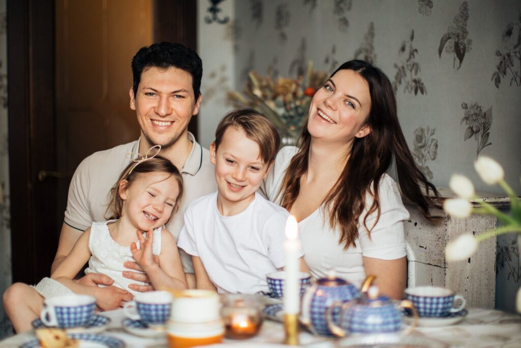 Loving family laughing at table having cozy meal, core values