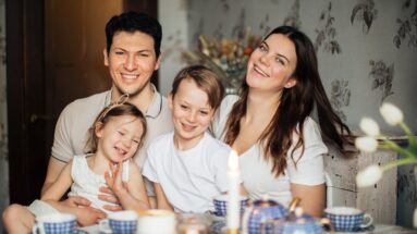 Loving family laughing at table having cozy meal, core values