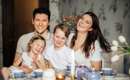 Loving family laughing at table having cozy meal, core values